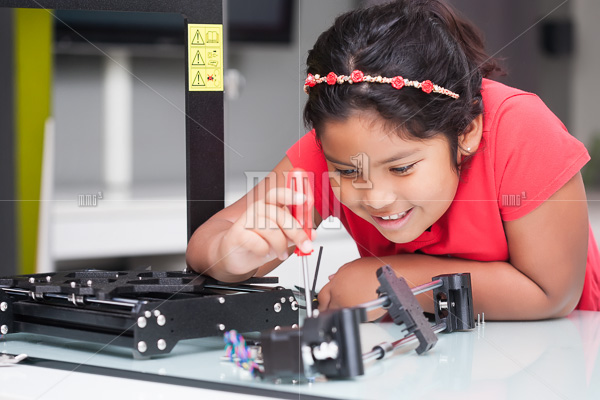 Genius level kid learning about 3D printers by building it and following directions in STEM class